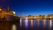 Um antigo barco de madeira em um porto à noite