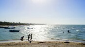 En la playa en Progreso, México, los visitantes caminan por la arena y nadan en el agua.