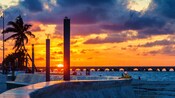 La puesta del sol detrás de un puente en Progreso, México.