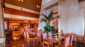 A restaurant dining area featuring high ceilings, plants and contemporary Mexican decor
