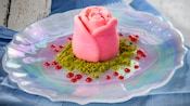 Panna cotta shaped beautifully into a rose in the middle of a plate 