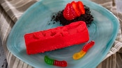 Gummy worms on a plate with strawberry white chocolate mousse