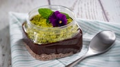 Chocolate pudding served with avocado cream, matcha crumb, pomegranate and baby herbs