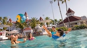 A family of 4 playing in a pool at Disney's Grand Floridian Resort & Spa A family of 4 playing in a pool at Disney's Grand Floridian Resort & Spa