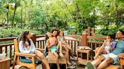 A family of 6 relaxing on a deck next to Cross Country Creek at Disney's Blizzard Beach water park
