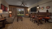 A guest room with a patio, sofa, 3 lamps, wall art, an upholstered chair, TV and a dining table with chairs