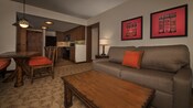Una sala de estar de una villa, con muebles tapizados, muebles en madera y una cocina