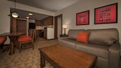 A sala de estar de uma Villa, com um mix de móveis de madeira e estofados e uma cozinha