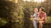 A man teaches his daughter how to fish