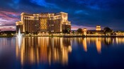 The sunsets over a grand hotel building and a large body of water