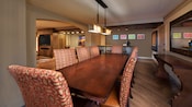 Una mesa de comedor de madera con 8 sillas en la sala de estar de una suite en Disney's Coronado Springs Resort
