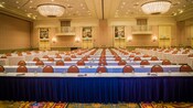 Several straight rows of tables and chairs in a ballroom