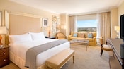 Una habitación de hotel con una cama King Size, un sofá y una vista de un campo de golf