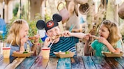 A family has lunch at an outside table in Harambe Market at Disney’s Animal Kingdom Theme Park A family has lunch at an outside table in Harambe Market at Disney’s Animal Kingdom Theme Park