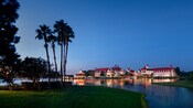 Disney's Grand Floridian Resort & Spa, a stately Victorian beach resort, on the shore of a lake lined with palm trees