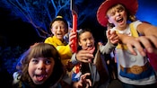 Four costumed kids making silly facial expressions