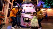 A mom, dad and their 2 kids strike a frightful pose with Vampire Mater in Cars Land