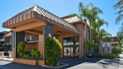 The carport overhang and entrance to Best Western Plus Stovall's Inn accented with palm trees