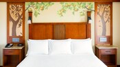 King size bed and 2 nightstands against a wall featuring a citrus tree motif King size bed and 2 nightstands against a wall featuring a citrus tree motif