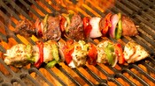 Skewers of meat and vegetables on a grill