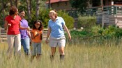 A girl shows her nature discovery to her mom, aunt and a guide