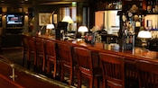 The old-fashioned bar, with wooden bar stools and counter, beer taps and a TV in the background