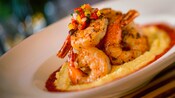 Grilled shrimp accented with a dollop of minced tomatoes, onions and peppers atop creamy cheese grits