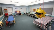 A large recreation room with long tables and sun piñata hanging from a rope
