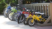 Multicolored row of children's and adults' bicycles in a bike rack