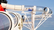 Two guests in a raft watersliding in an acrylic translucent loop that extends over the side of ship