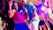 A couple dancing and laughing on the dance floor of a nightclub