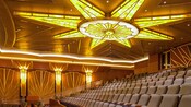 A large theater with stadium tiered rows and comfortable, padded chairs