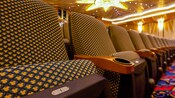 The fabric on a row of theater chairs has Mickey Mouse worked into the pattern