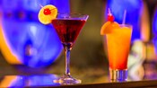 Uma taça de martini comporta uma bebida refrescante condimentada com uma fatia de limão e uma cereja