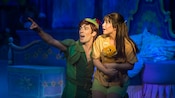 Peter Pan points upward while a young girl looks on during a performance of the Disney Dreams, An Enchanted Classic musical show