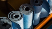 Top view of 4 rolled up workout mats lined up and ready for use