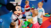 Three little girls and a little boy play a game with Minnie Mouse at Flounders Reef Nursery