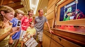 A family holds on to a game card and a map, by enchanted art, to play the Muppet Adventure Game