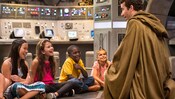 Un guerrero Jedi recibe la atención de un grupo de niños en un escenario de nave espacial