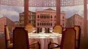 An elegant dining table with 6 chairs by a mural of Venice Italy, at Palo restaurant