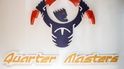 A sign with a depiction of video game player says, Quarter Masters