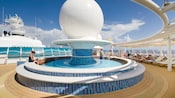 A curtain of water gently cascades into the center of a circular splash pool with built in benches