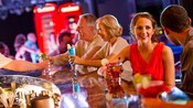 Huéspedes sentados en una barra disfrutan de sus bebidas en The Tube Nightclub