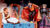 Un misterioso hombre con sombrero de copa y capa aparece en el salón de Cenicienta mientras esta sujeta su zapatilla de cristal