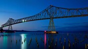 A bridge stretches over a bay dotted with partially submerged pillars