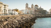 Concrete blocks fortify the shoreline next to old buildings in Cadiz Spain