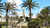 Personas cerca de árboles, edificios y un monumento