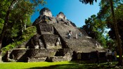 Personas subiendo los escalones empinados de una antigua ruina maya en Costa Maya, México