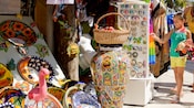 A marketplace for cultural art with pottery, figurines and jewelry is visited by a little girl