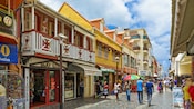 Um mercado francês com compradores descendo sua rua de pedras